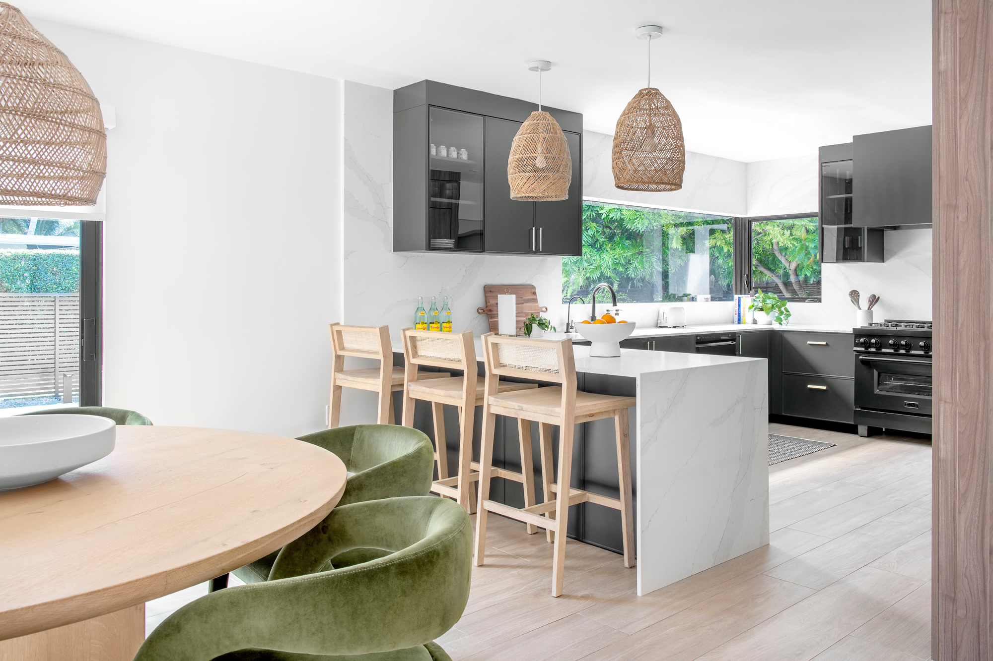 Modern kitchen with dark cabinetry and woven pendants