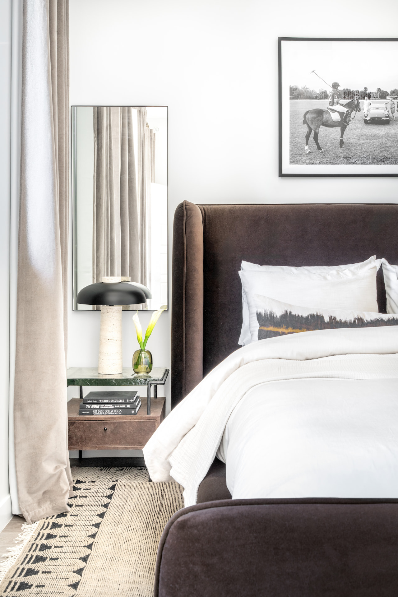 Bedroom with brown velvet bed and black-and-white art