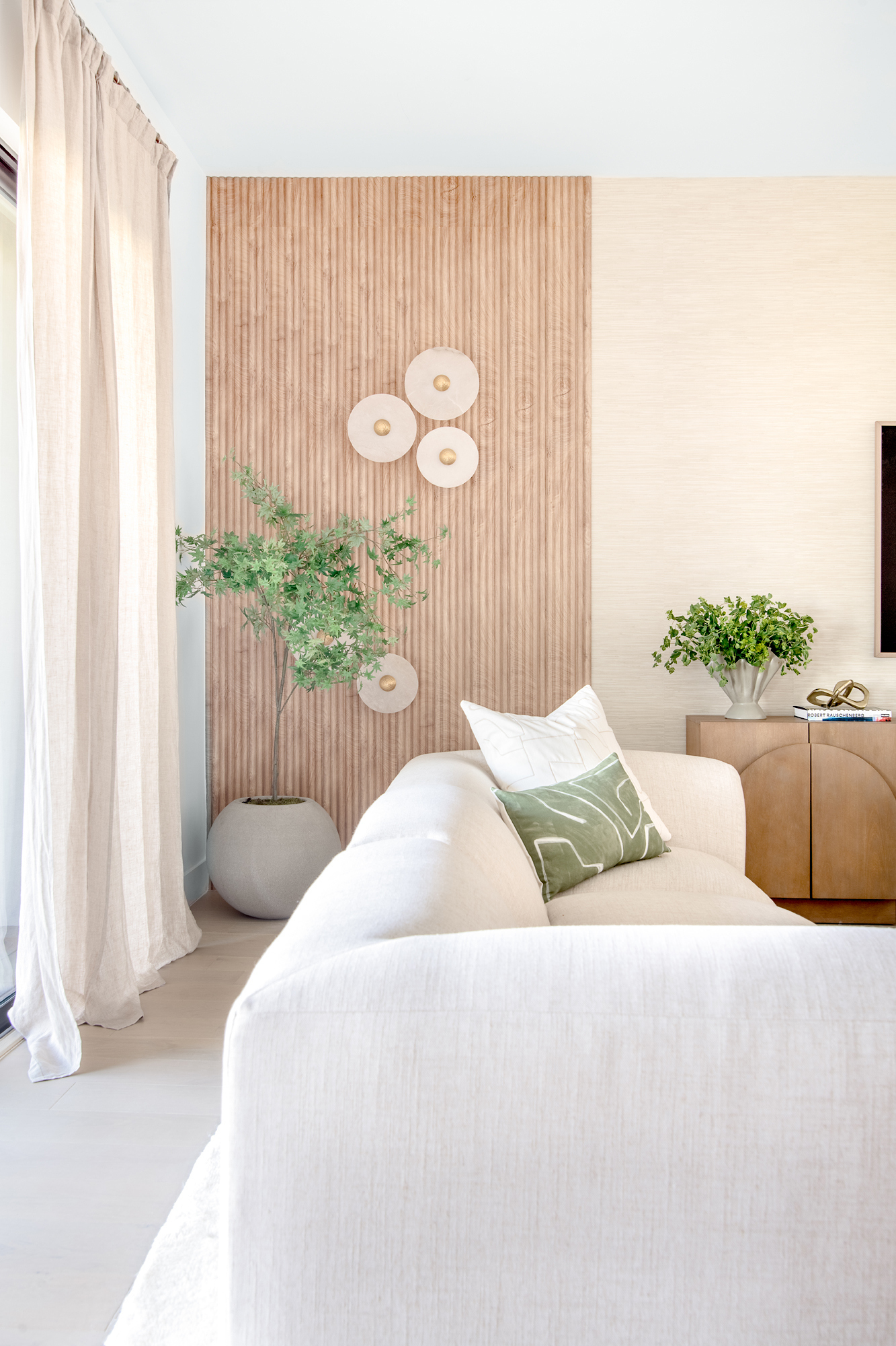 Living room with slatted oak wall and linen sofa
