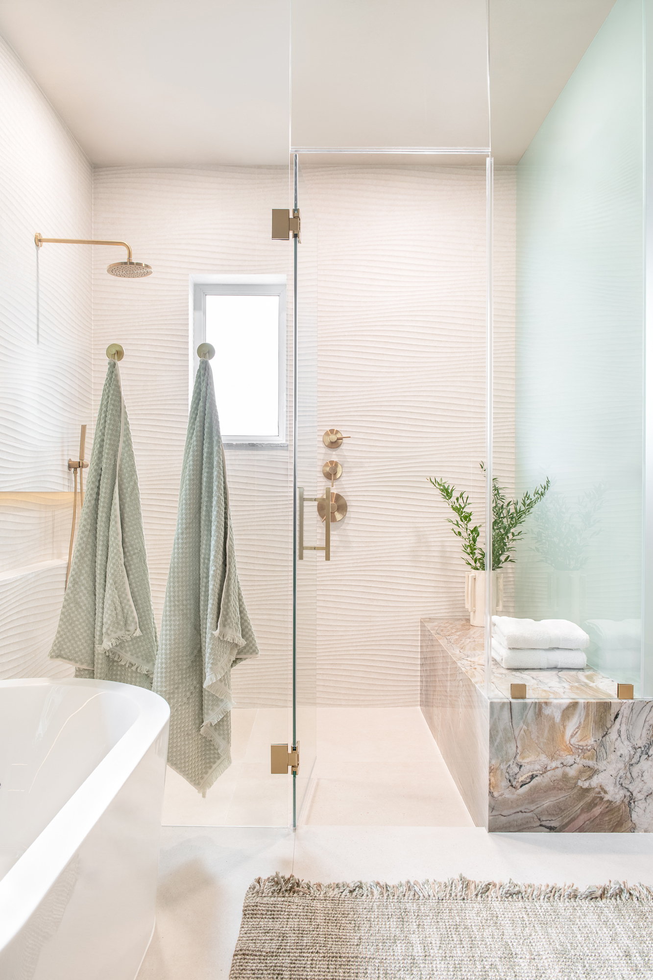 Wave-tile shower with brass fixtures and stone bench